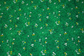 Grøn patchwork-bomuld med græs, små tusindfryd og mælkebøtter