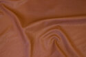 Blød, lysbrun imiteretskind med let præget overflade